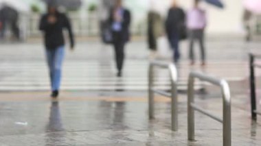 Shinagawa Tokyo 'da yağmurlu bir günde şehir merkezinde yürüyen insanlar.