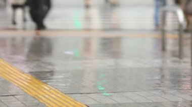 Shinagawa Tokyo 'da yağmurlu bir günde şehir merkezinde yürüyen insanlar.