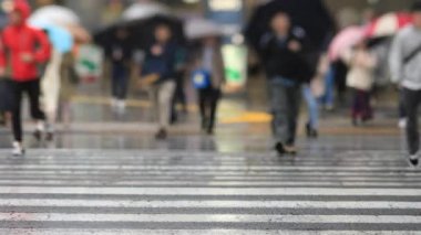 Shinagawa Tokyo 'da yağmurlu bir günde şehir merkezinde yürüyen insanlar.