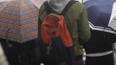 Shinagawa Tokyo 'da yağmurlu bir günde şehir merkezinde yürüyen insanlar.