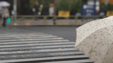 Shinagawa Tokyo 'da yağmurlu bir günde şehir merkezinde yürüyen insanlar.