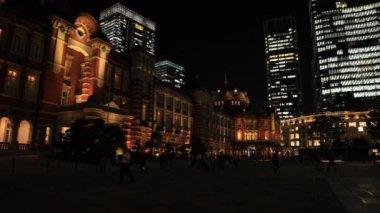Tokyo 'daki iş kasabasında yürüyen insanların olduğu bir gece manzarası.