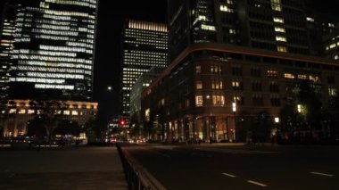 Tokyo 'daki iş kasabasında yürüyen insanların olduğu bir gece manzarası.