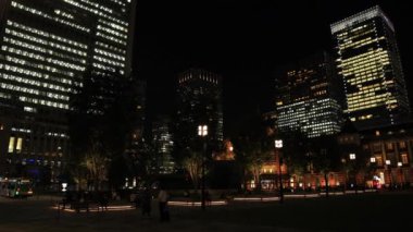 Tokyo 'daki iş kasabasında yürüyen insanların olduğu bir gece manzarası.