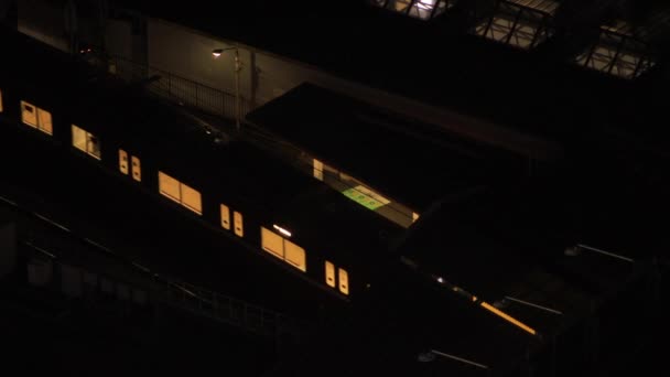 Um trem na estação de Shinagawa em Tóquio à noite — Vídeo de Stock