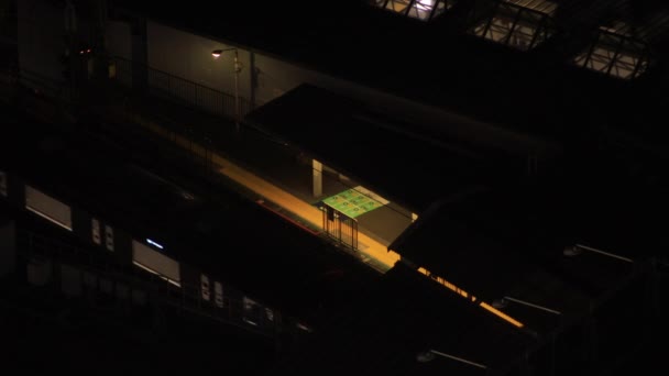 Un tren en la estación Shinagawa en Tokio por la noche — Vídeo de stock