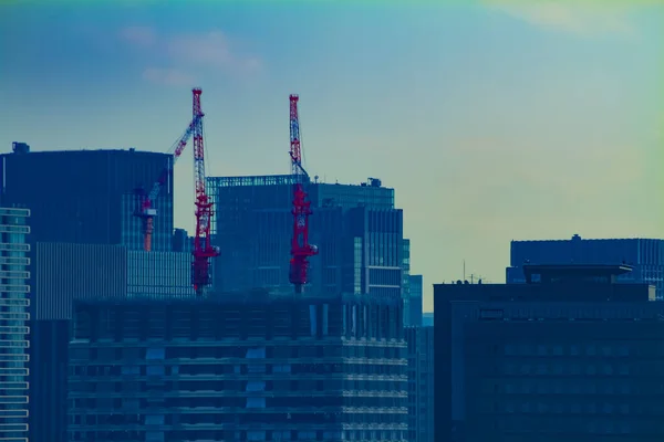 Grúas en movimiento en la parte superior del edificio en Tokio tiro largo — Foto de Stock