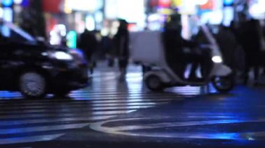 Moving cars at the night crossing in Shinjuku Tokyo rainy day