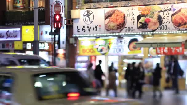 Bergerak mobil di malam hari persimpangan di Shinjuku Tokyo hari hujan — Stok Video