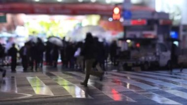 Walking people at the crossing in Shinjuku Tokyo rainy day at night