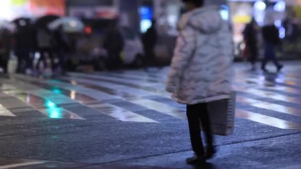 Lopende mensen bij de kruising in Shinjuku Tokio regenachtige dag 's nachts — Stockvideo