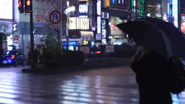 Caminar a la gente en el cruce en Shinjuku Tokio lluvioso día por la noche — Vídeo de stock
