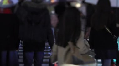 Walking people at the crossing in Shinjuku Tokyo rainy day at night