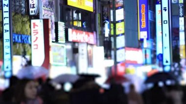 Walking people at the crossing in Shinjuku Tokyo rainy day at night