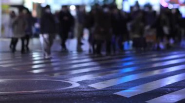 Walking people at the crossing in Shinjuku Tokyo rainy day at night