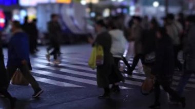 Walking people at the crossing in Shinjuku Tokyo rainy day at night