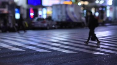 Walking people at the crossing in Shinjuku Tokyo rainy day at night