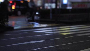 Walking people at the crossing in Shinjuku Tokyo rainy day at night