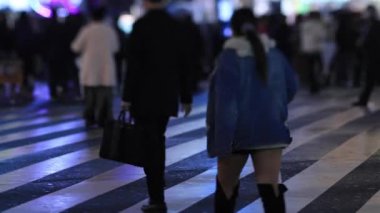 Walking people at the crossing in Shinjuku Tokyo rainy day at night