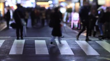 Walking people at the crossing in Shinjuku Tokyo rainy day at night