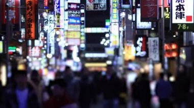 Walking people at the crossing in Shinjuku Tokyo rainy day at night