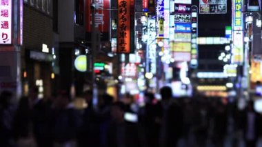 Walking people at the crossing in Shinjuku Tokyo rainy day at night
