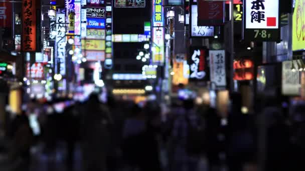 Lopende mensen bij de kruising in Shinjuku Tokio regenachtige dag 's nachts — Stockvideo