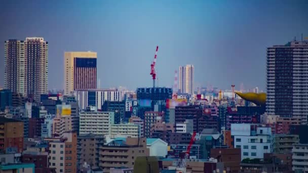 Een tijdspanne van bewegende kranen aan de bovenkant van het gebouw in Tokyo lange schot kantelen — Stockvideo