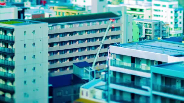 Sebuah tiLapse crane bergerak di atas bangunan di Tokyo tiltshift zoom — Stok Video