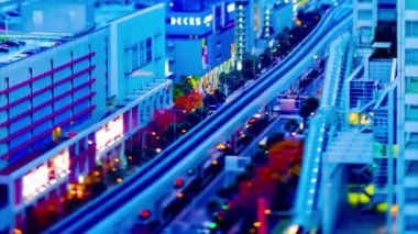 Tokyo demiryolundaki trenin alacakaranlık zamanı yüksek açılı eğim kayması.