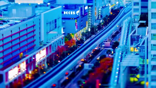 도쿄의 높은 각도로 기울어져 있는 철로 위를 달리고 있는 해질 녘의 열차 — 비디오