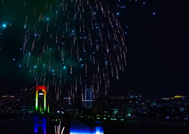 Tokyo 'daki şehir şehrinde Gökkuşağı köprüsü yakınlarında bir gece havai fişeği gösterisi