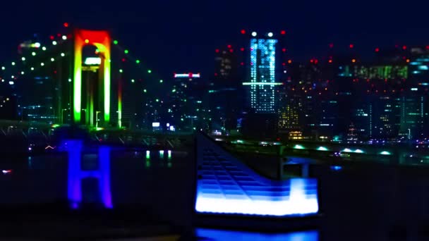 Ночной хронометраж миниатюрного радужного моста в городском городе Токио, наклонный зум — стоковое видео
