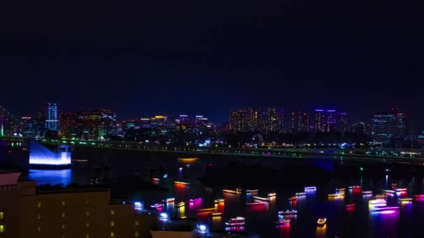 En natt timelapse av fartyg vid Rainbow Bridge på den urbana staden i Tokyo bred skott panorering — Stockvideo