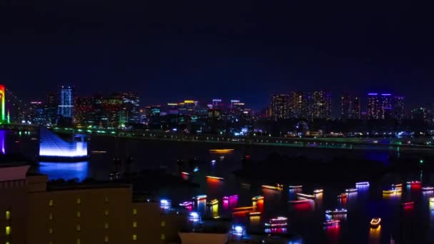Un timelapse nocturno de barcos en el puente Rainbow en la ciudad urbana de Tokio zoom de tiro ancho — Vídeos de Stock