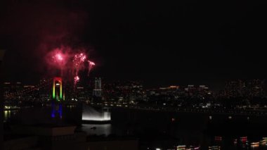 Tokyo 'daki şehir şehrinde Gökkuşağı köprüsü yakınlarında gece havai fişekleri