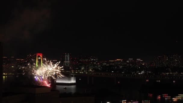 Νυχτερινά πυροτεχνήματα κοντά στη γέφυρα Rainbow στην πόλη του Τόκιο — Αρχείο Βίντεο