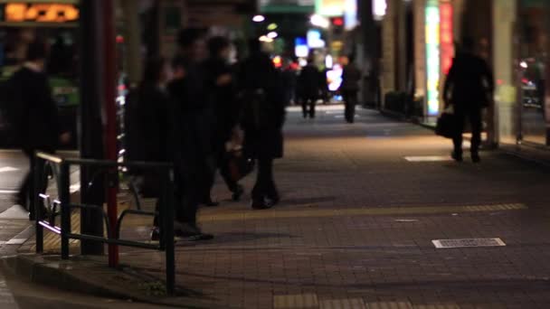 Lopende mensen in de neon stad in Shinbashi Tokio 's nachts lange shot handheld — Stockvideo