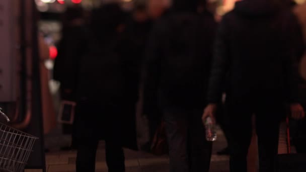 Lopende mensen in de neon stad in Shinbashi Tokio 's nachts lange shot handheld — Stockvideo