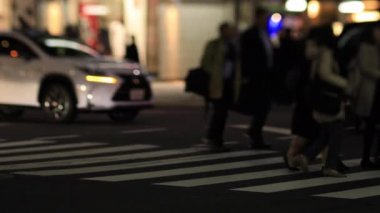 Shinbashi Tokyo 'nun neon kasabasında gece vakti yürüyen insanlar.