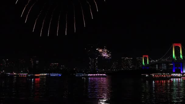 En natt fyrverkerier nära Rainbow bron i den urbana staden i Tokyo bred skott — Stockvideo