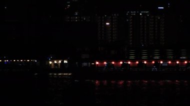Tokyo 'nun şehir merkezindeki körfez bölgesine gece vakti neon tekne nakliyesi.