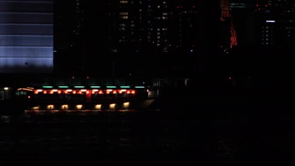 Moving neon boat nat the bay area in the urban city in Tokyo at night long shot — Stock Video