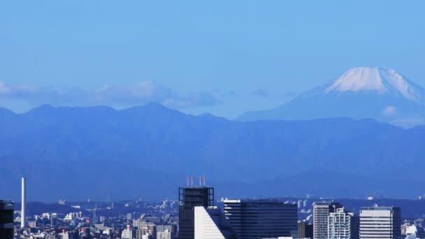 Un paisaje urbano de ángulo alto en la ciudad urbana detrás del monte. Fuji en Tokio tiro largo durante el día — Vídeo de stock