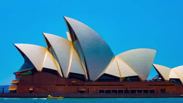 Een tmelapse van de Opera huis in de buurt van de haven in Sydney gok panning — Stockvideo