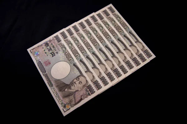 Moeda japonesa 100.000 ienes no fundo preto — Fotografia de Stock
