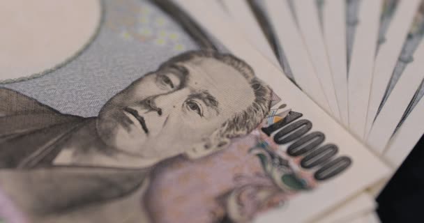 Monnaie japonaise 100,000 yen sur le fond noir gros plan — Video