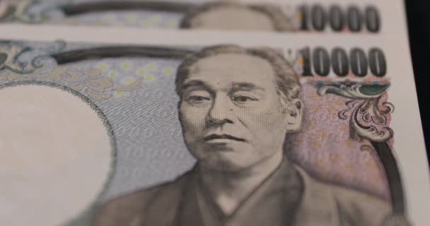 Ιαπωνικό νόμισμα 100.000 γιεν στο μαύρο φόντο closeup — Αρχείο Βίντεο