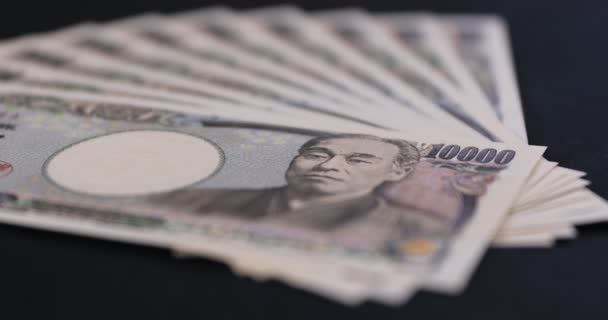 Japońska waluta 100.000 jenów na czarnym tle — Wideo stockowe