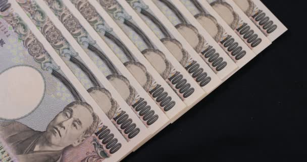 Moneda japonesa 100.000 yenes en el fondo negro — Vídeo de stock